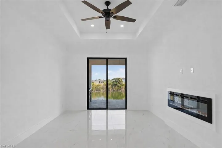 Primary bedroom with view towards the lanai, outdoor kitchen, canal