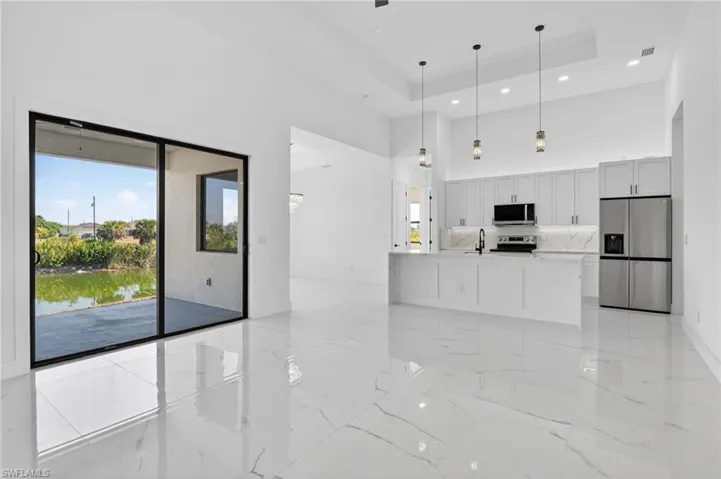 Unfurnished living room with a raised ceiling, a water view, and recessed lighting