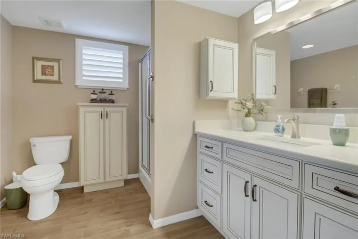 Bathroom featuring vanity, an enclosed shower, toilet, and hardwood / wood-style floors