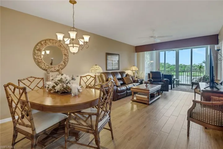 Dining space with ceiling fan with notable chandelier and light wood-type flooring