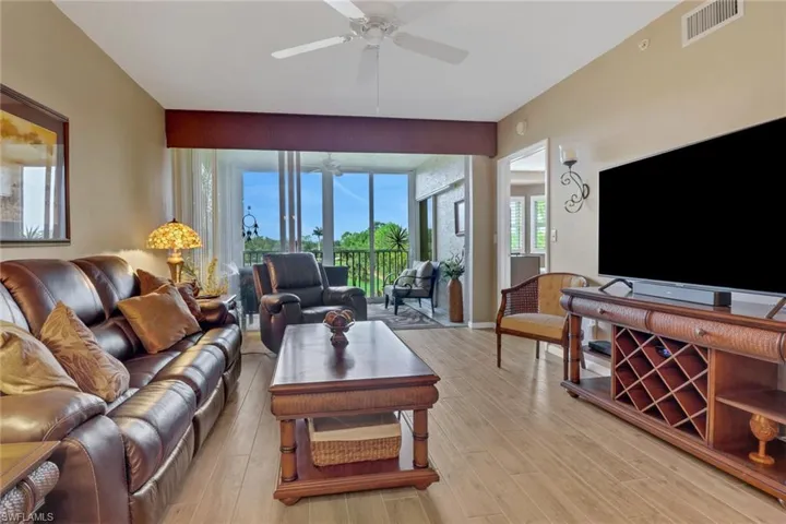 Living room with light hardwood / wood-style floors, ceiling fan, and plenty of natural light