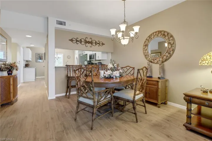 Dining room with light hardwood / wood-style floors, a wealth of natural light, and a chandelier