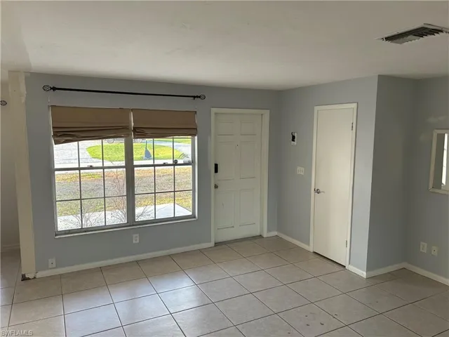 Foyer entrance with baseboards and light tile patterned flooring