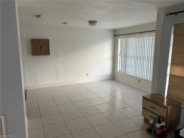 Unfurnished room with light tile patterned floors and baseboards