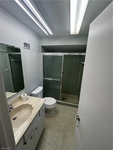 Bathroom with vanity, a stall shower, and light tile patterned flooring