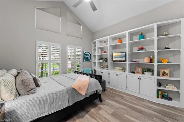 Bedroom featuring ceiling fan, high vaulted ceiling, and light wood-type flooring