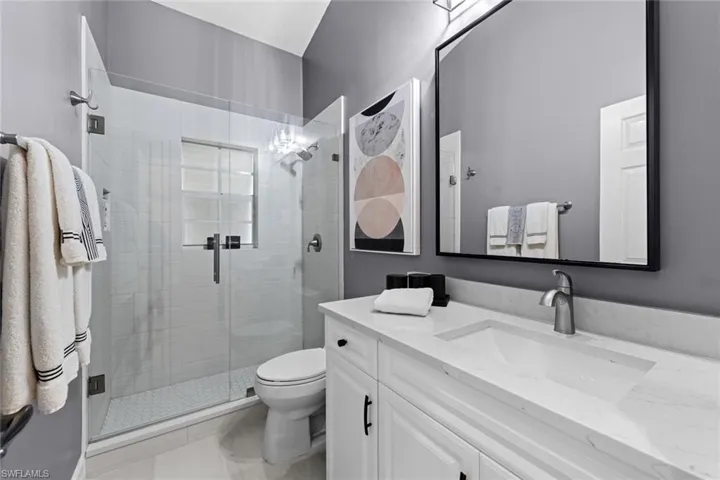 Bathroom with walk in shower, vanity, and toilet