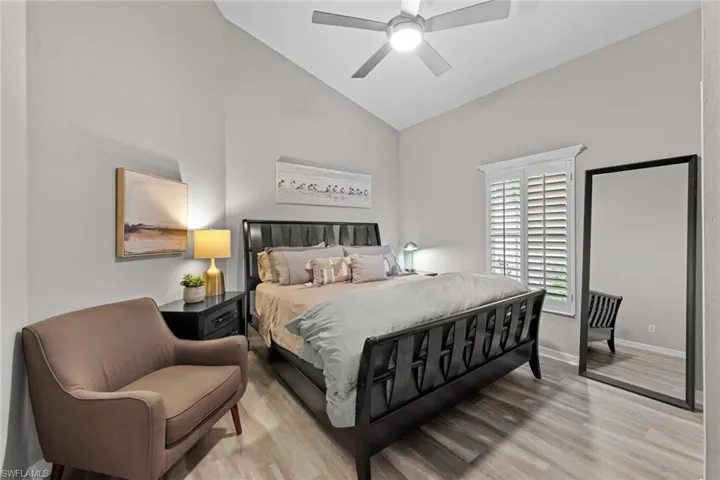 Bedroom featuring ceiling fan, light hardwood / wood-style flooring, and high vaulted ceiling