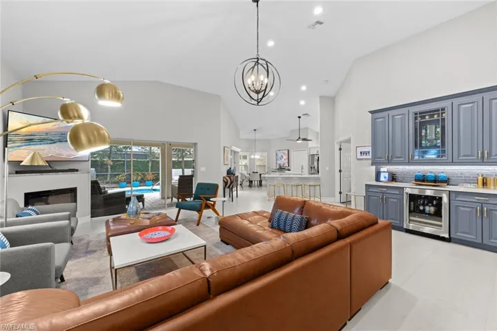 Living room with high vaulted ceiling, bar area, and wine cooler