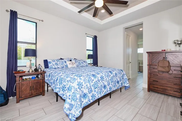 Bedroom featuring ceiling fan and a tray ceiling