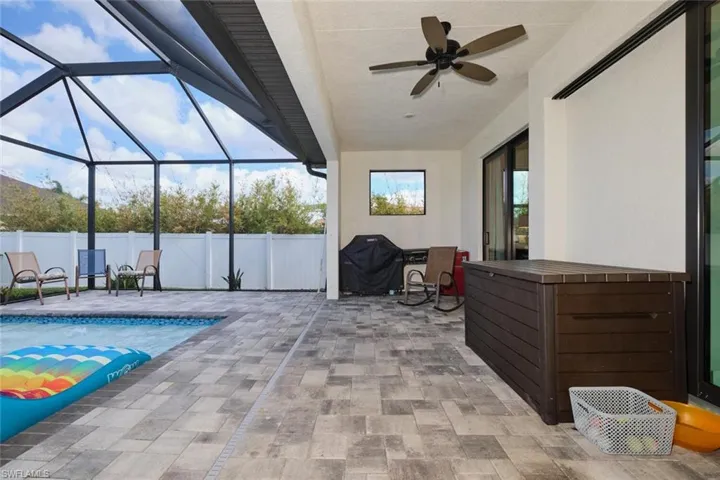 View of patio / terrace featuring a lanai, area for grilling, ceiling fan, and a fenced in pool