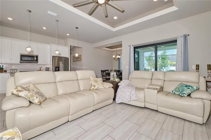 Living room featuring ceiling fan and tray ceiling