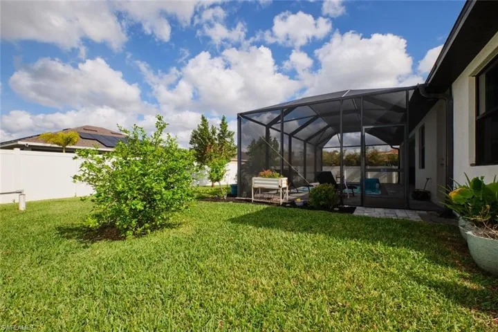 View of yard featuring screened pool and fence