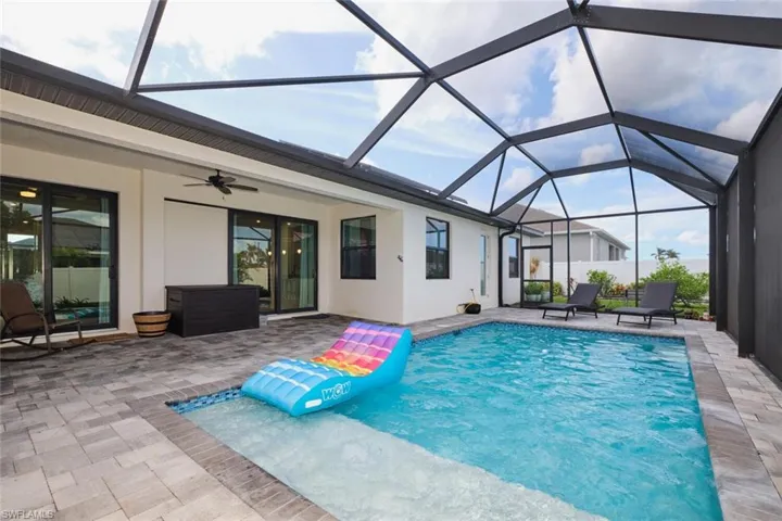 View of pool with ceiling fan, a patio, and a lanai