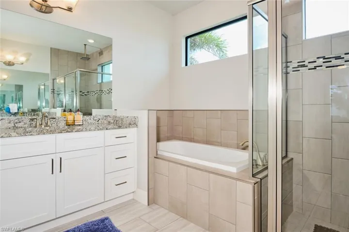 Bathroom featuring independent shower and bath, vanity, and tile patterned floors