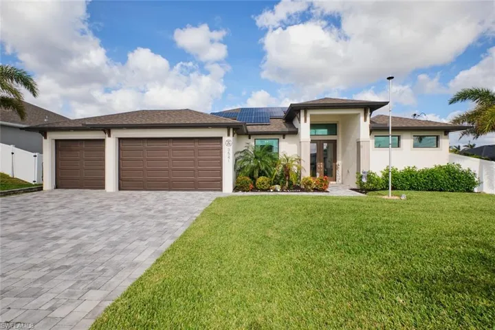 modern-style home with a three car garage and  paver driveway and solar panels