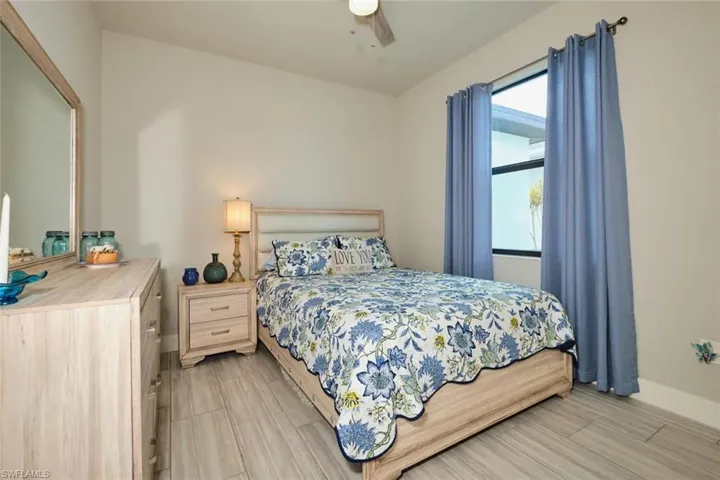 Bedroom #2 featuring wood look tile flooring and ceiling fan fan