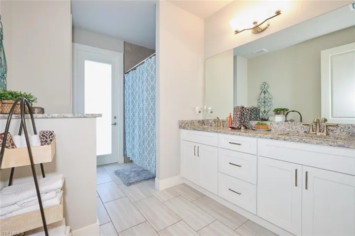 Bathroom with tub/ shower, vanity and access to pool