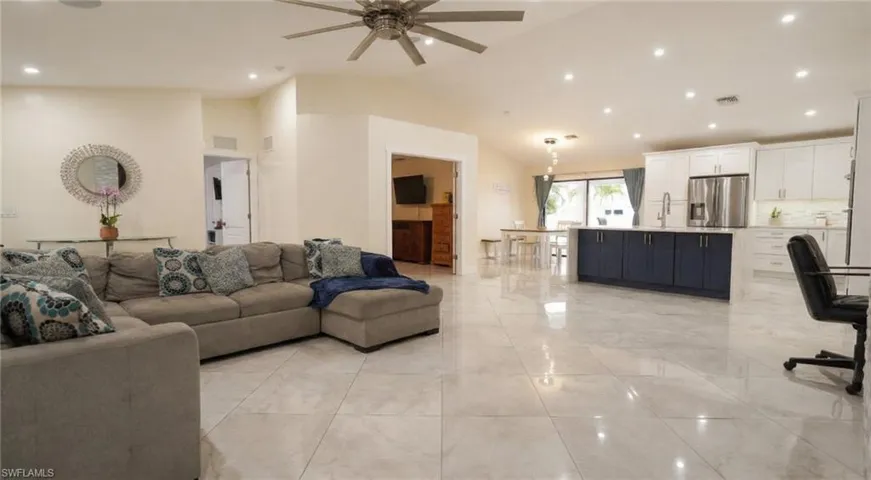 Living area with recessed lighting, ceiling fan, and high vaulted ceiling