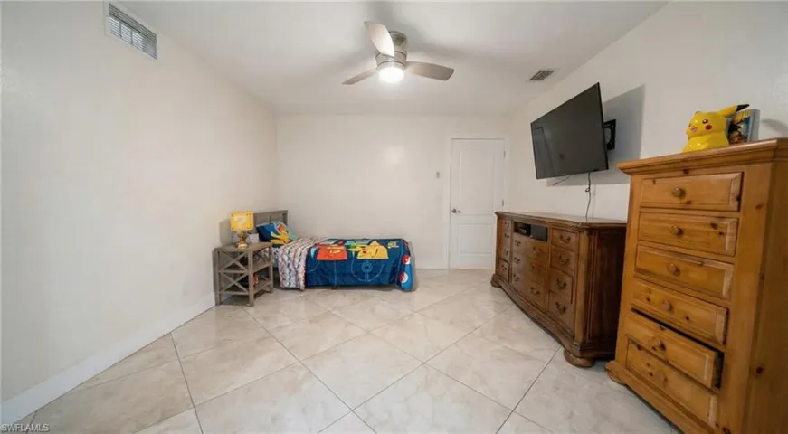 Bedroom with a ceiling fan and light tile patterned flooring