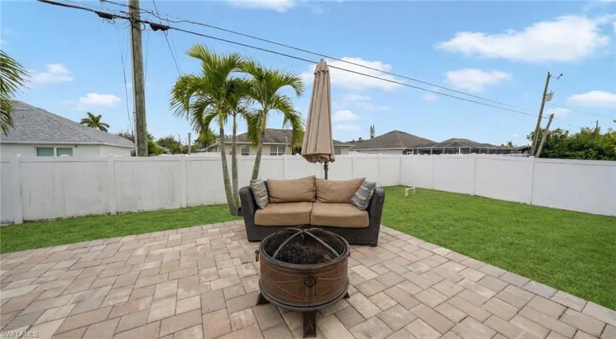 Fenced backyard featuring a patio area and a fire pit
