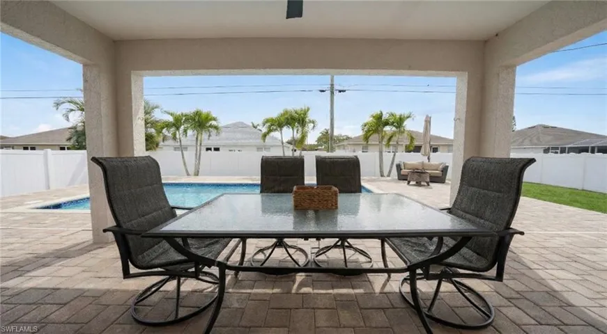 Fenced backyard featuring outdoor dining space, a patio, and a ceiling fan