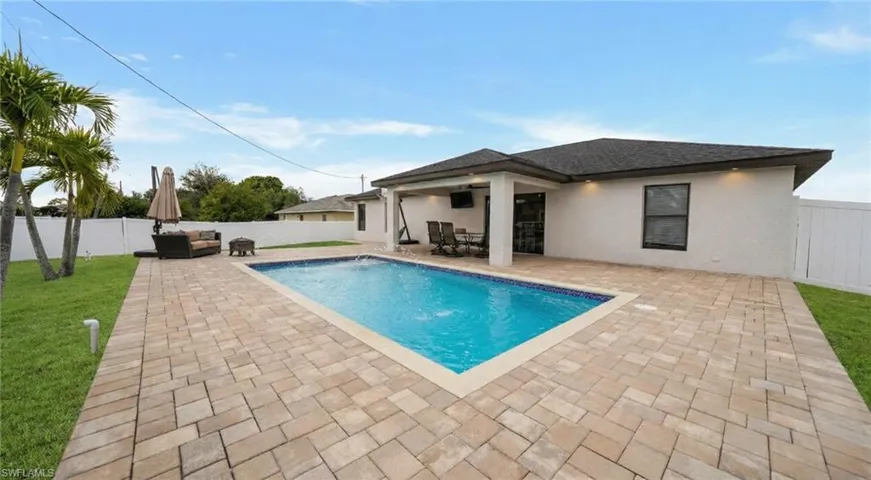 View of swimming pool with a patio and a fenced backyard