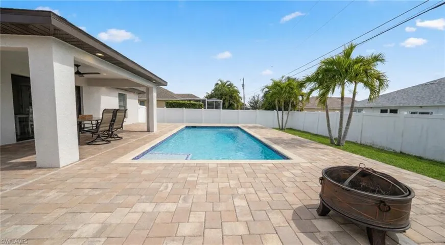 View of swimming pool featuring a patio, a fenced backyard, an outdoor fire pit, and outdoor dining space