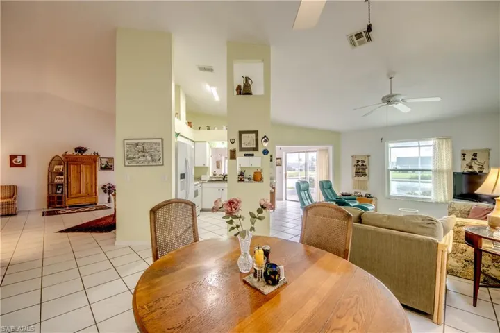 Casual Dining space featuring ceiling fan, light tile floors, and lofted ceiling.  Home is very open and bright with water views all around.