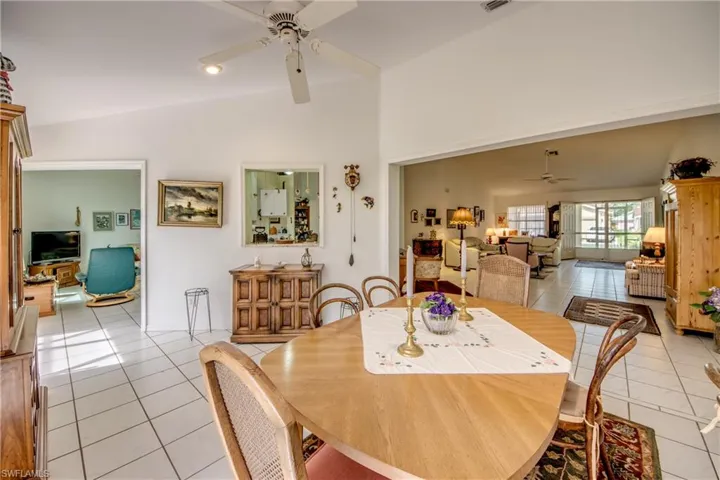 Tiled dining room featuring ceiling fan and lofted ceiling