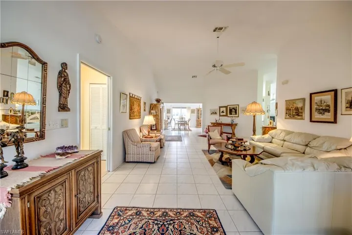 Living room with ceiling fan and light tile flooring