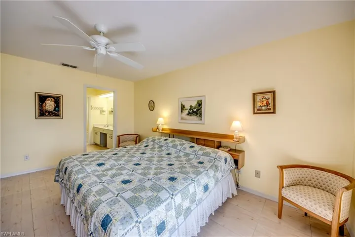 Tiled bedroom with ceiling fan and ensuite bath