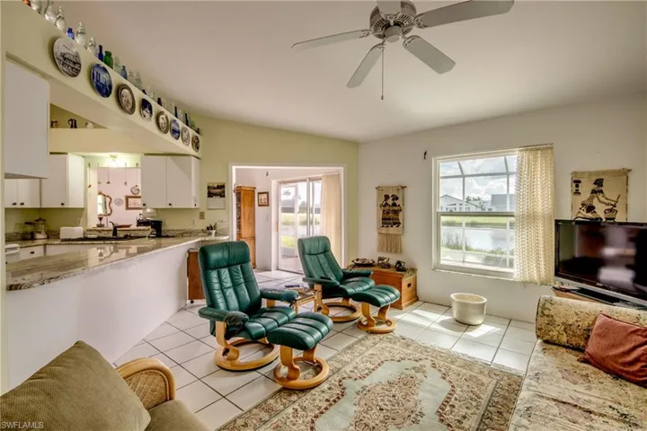 Family room with ceiling fan, light tile flooring, and sink.  Great views of golf course and water feature
