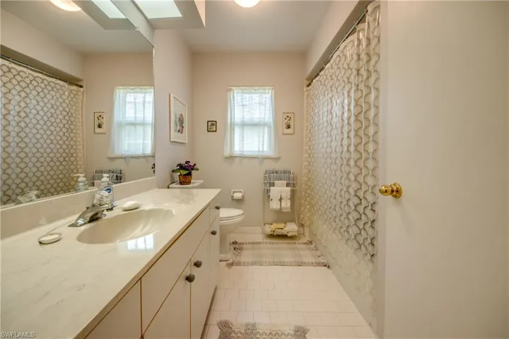 Bathroom featuring tile floors, tub, vanity and large linen closet.