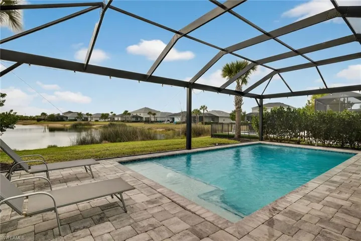 Outdoor pool with a lanai, a residential view, a sunroom, and a yard