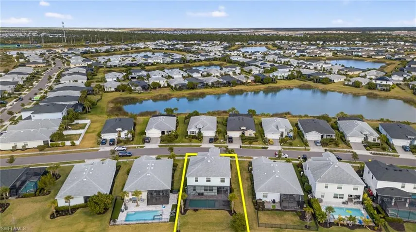 Aerial perspective of suburban area with property boundaries highlighted and a large body of water