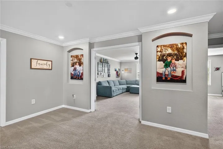 Hallway with crown molding, light carpet, and recessed lighting