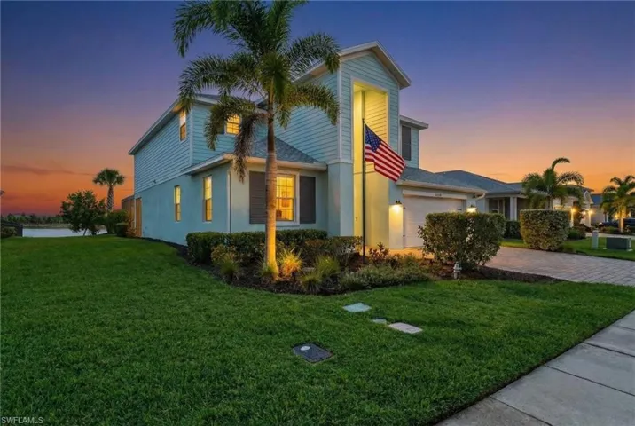 View of side of property with a lawn, driveway, a garage, and stucco siding