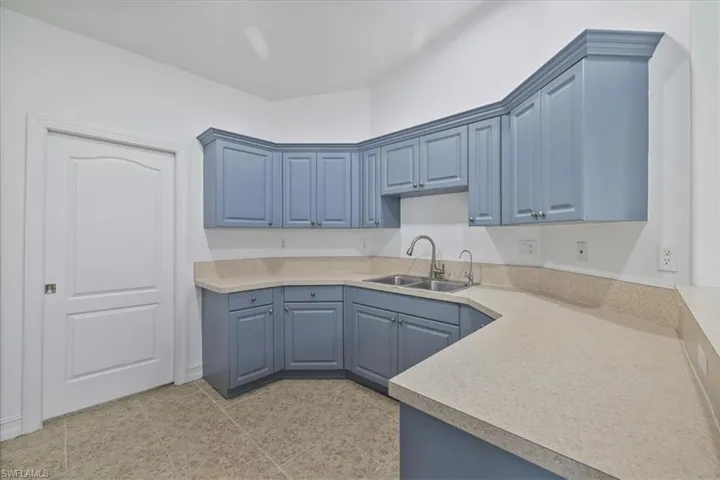 Kitchen featuring blue cabinetry, light countertops, and light tile patterned flooring