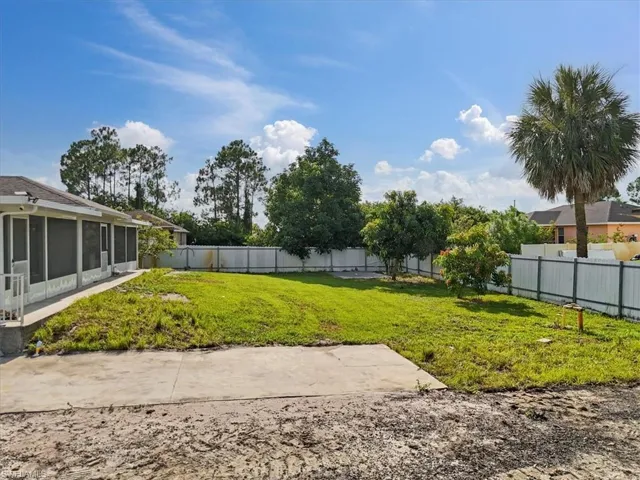 Fenced backyard featuring a sunroom