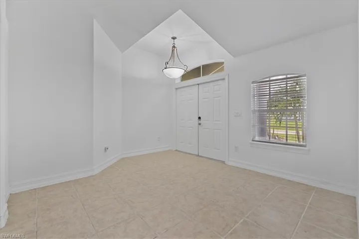 Entryway featuring lofted ceiling and tile patterned flooring