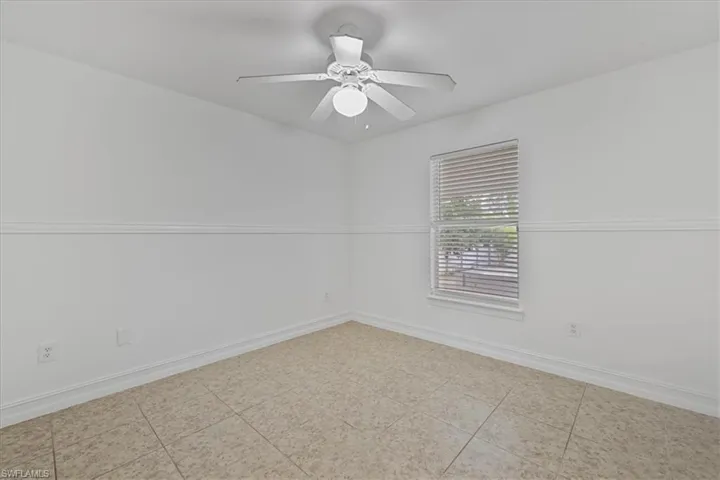 Empty room featuring baseboards and ceiling fan