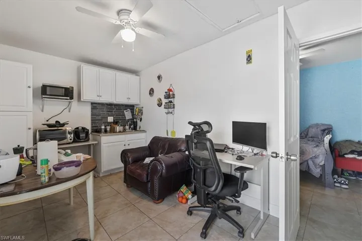 Office with ceiling fan and light tile patterned flooring