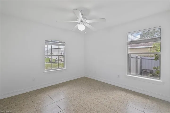 Spare room featuring ceiling fan and light tile patterned floors