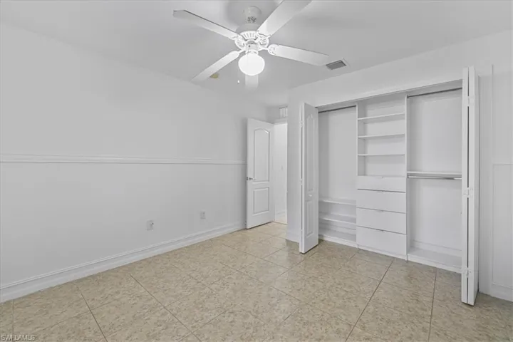 Unfurnished bedroom featuring a ceiling fan and a closet