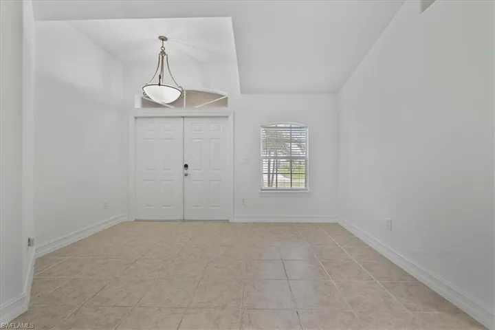 Entryway featuring baseboards and light tile patterned floors