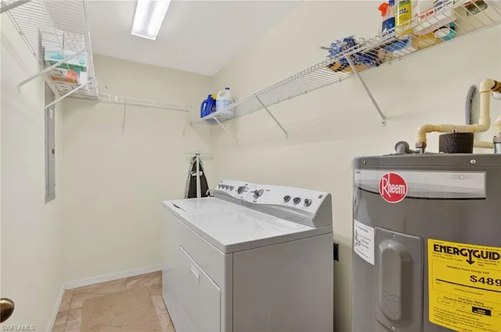 Laundry room featuring electric water heater and washing machine and clothes dryer