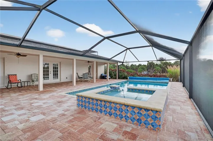 Integrated pool / spa featuring a sunroom, a patio, french doors, and glass enclosure