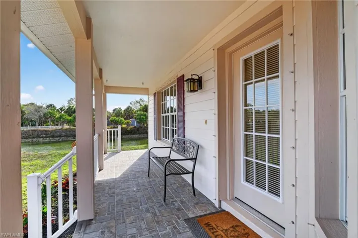 Covered porch featuring a water view