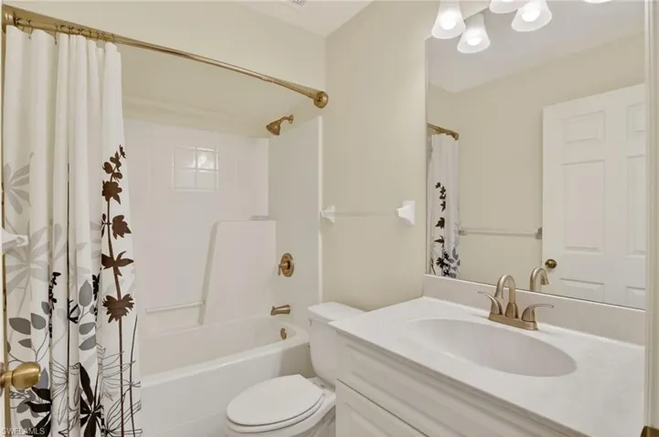 Bathroom with vanity and shower / tub combo with curtain